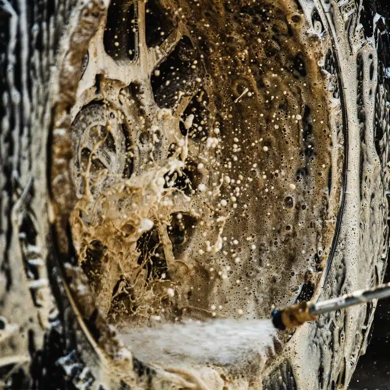 Buddy's Blends Aquaterge Industrial Degreaser Cleaner being used to clean a tire with a pressure washer