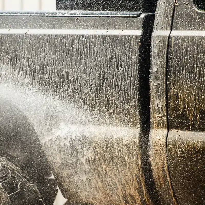 Buddy's Blends SUPERBLUE truck fleet cleaner being used to clean a truck with a pressure washer