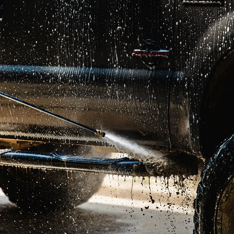 Buddy's Blends industrial cleaning solutions SUPERBLUE truck fleet cleaner being used to clean a truck with a pressure washer
